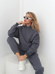 Stylish female model poses effortlessly in trendy athleisure wear in modern studio space