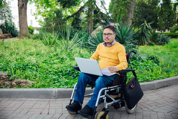 Man in wheelchair working with laptop negotiating business