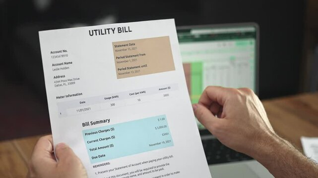 Elderly man directs finger at specific text on utility bill copying onto computer, male accountant reviews papers analyzing expenses related to office services slow motion