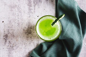 Close up of fresh cucumber juice in a glass and cucumber piece on the table top view