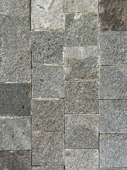 Close up of flat andesite slate stone or grey paving stone. Suitable for wall finishes, cladding, or outdoor floor materials. Good for pavement and sidewalk. Seamless background texture.