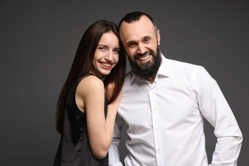 Portrait of happy daughter and father on dark grey background