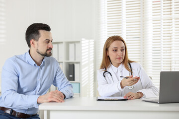 Man having consultation with cardiologist at desk in clinic