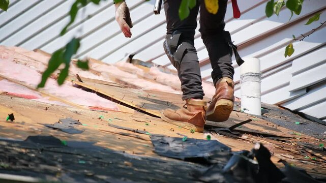 Roofer remove old wood decking of the damaged roof before installing a new covering on an house. Work elements