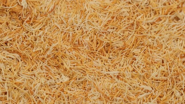 Zoom frame Baked shredded Kataifi dough or Kadayif dough, rotation. Ingredients for making trendy Dubai chocolate and other desserts