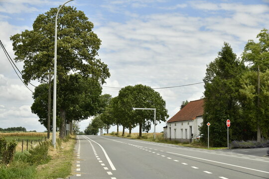 Route nationale traversant la campagne devant une fermette abandonn&eacute;e &agrave; Ghislenghien (Ath)