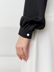 Elegant fashion model showcasing a stylish black sleeve in a minimalist studio setting