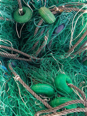 Fishing net background. A pile of fishing nets to dry, close-up. Fishing nets, ropes, and buoys. Fishing gear.