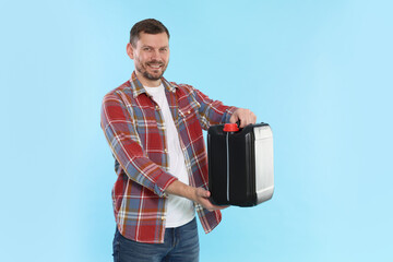 Man holding plastic canister on light blue background