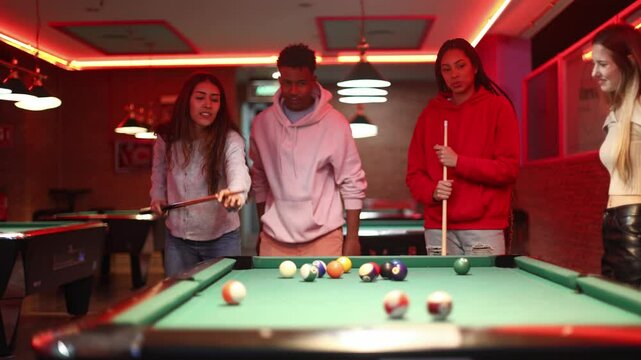 Friends playing billiards in a pool hall