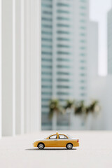 bright minimalist photograph of taxi against backdrop of modern skyscrapers featuring single accent vehicle in