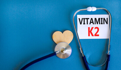 Vitamin K2 phylloquinone symbol. Concept words Vitamin K2 on beautiful white card. Wooden heart and...