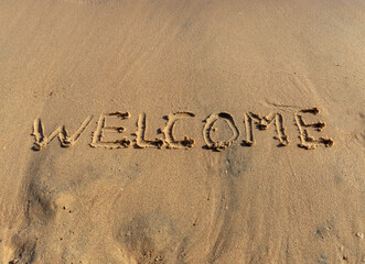 Fototapeta premium Business hello and welcome concept. Concept word Welcome written on beautiful Red sea ocean sand beach. Beautiful Red sea ocean sand beach background, copy space. Business hello and welcome concept.