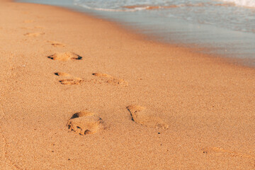 Footstep in wet beach sand in summer, holiday and vacation by the sea background