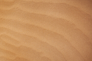 Texture of brown wavy sand on ocean beach