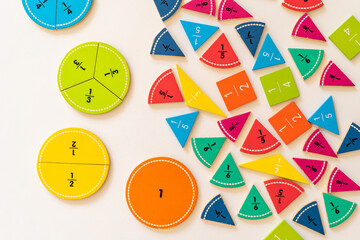 Colorful fraction educational tools arranged on a white surface for interactive learning and teaching purposes. education,  back to school
