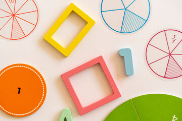 Colorful learning materials are arranged on a table to teach numbers and shapes in an early...