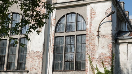 Stary budynek z dużym oknem i latarnią zamocowaną na elewacji budynku