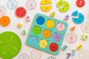 Educational color-coded fractions and mathematical tools displayed on a table for learning...