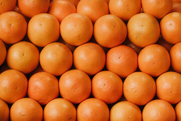 Beautiful oranges displayed in a row on a stall in the fruit and vegetable market