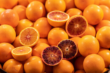Beautiful oranges displayed in a row on a stall in the fruit and vegetable market with some oranges cut open in half