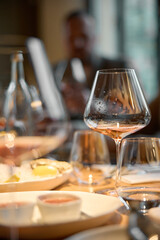 Champagne tasting, Wine glasses are on the table, stylish table setting, wine is poured from a bottle and decanter, sparkling wine bubbles, snacks, people smell the aroma and taste the wine