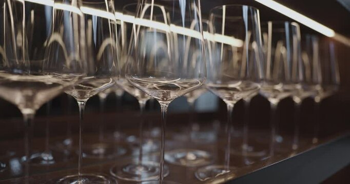 Clean wine glasses are in the wine cabinet in restaurant, local illumination