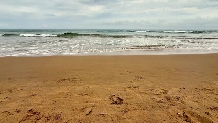 A beautiful and serene seashore featuring gentle waves, soft sandy beach, and peaceful surroundings