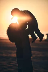 Silhouette of mother holding young kid in the air at beach on sunset. High quality photo © Florian Kunde