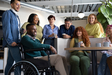 Coworkers enjoying a coffee break, chatting and laughing together in an inclusive workplace