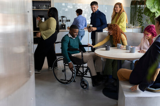 Diverse business team enjoying coffee break in modern coworking space