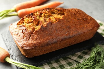 Tasty carrot cake and vegetables on grey table, closeup
