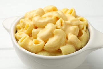 Delicious macaroni and cheese on white wooden table, closeup
