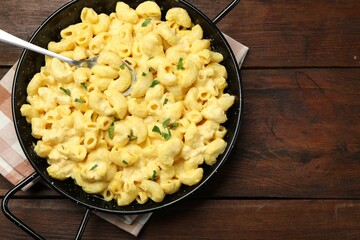 Delicious pasta with cheese sauce on wooden table, top view. Space for text