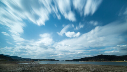 chmury sunące nad brzegiem jeziora