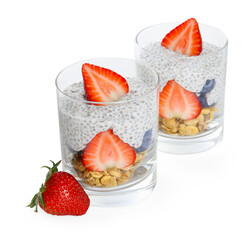 Delicious dessert with chia seeds, yogurt, granola, strawberries and blueberries in glasses isolated on white. Superfood