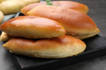 Tasty baked patties on grey textured table, closeup