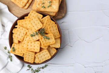 Tasty salty crackers and thyme on white textured table, flat lay. Space for text