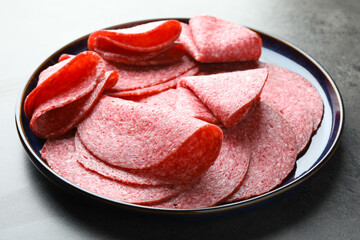Slices of delicious sausage served on grey table, closeup