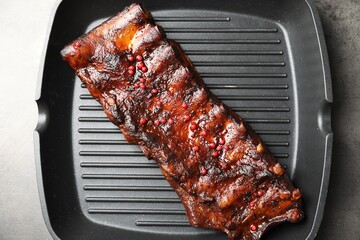 Delicious roasted pork ribs on grey table, top view