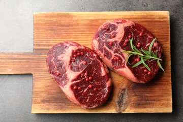 Pieces of raw beef meat and spices on gray table, top view