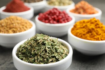 Different aromatic spices on grey table, closeup
