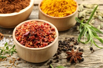 Different aromatic spices on wooden table, closeup