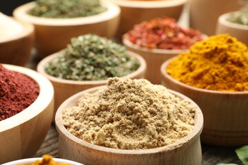 Different aromatic spices in bowls on table, closeup