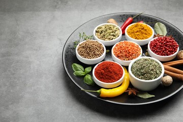 Different aromatic spices on grey table, closeup. Space for text