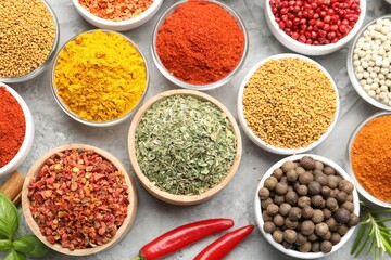 Different aromatic spices on grey table, flat lay