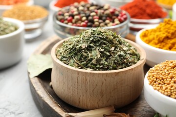 Different aromatic spices in bowls on grey table, closeup