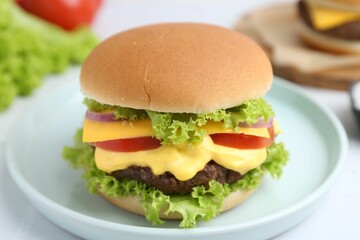 Tasty cheeseburger with lettuce and tomatoes on white table, closeup