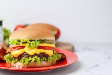 Tasty cheeseburger on white marble table, closeup. Space for text