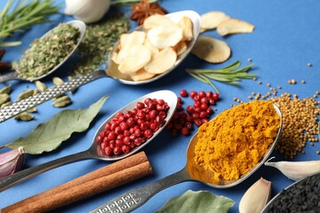 Different aromatic spices on blue background, closeup
